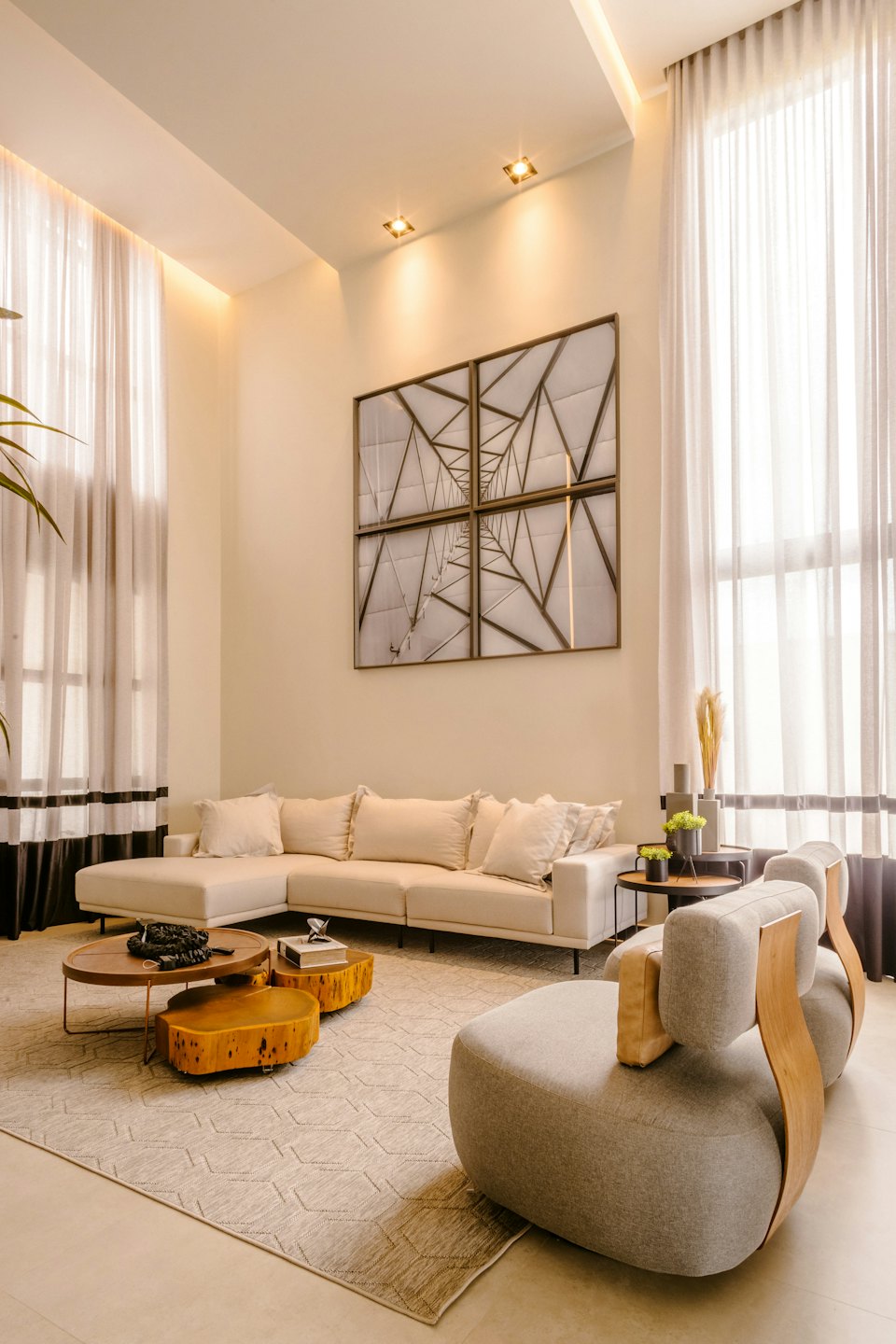 Modern living room with cream sofa and grey armchairs.